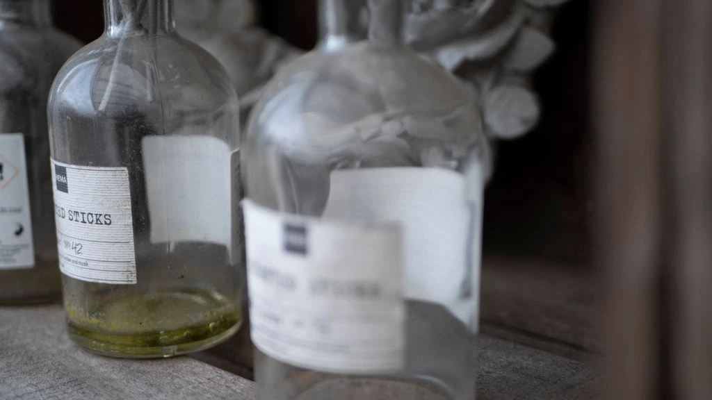 Apothecary bottles and dried botanicals on a linen-covered atelier table in Sayulita.